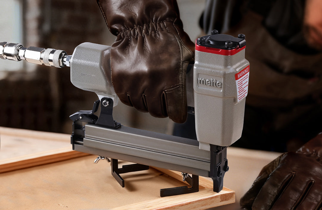 Meite USA V1015B pneumatic nail gun used to fasten nails on a picture frame, demonstrating precise woodworking and home DIY applications